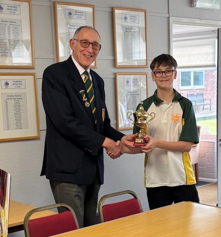 Logan being presented with trophy.